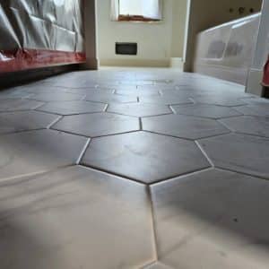 Bathroom floor with large hexagonal white tiles, creating a clean and minimalist look that enhances the spacious feel of the room.